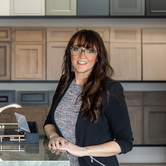 Crystal Shivers standing in an Exclusively Cabinets showroom